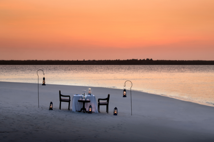 Sunset beachfront dinner setup for wedding