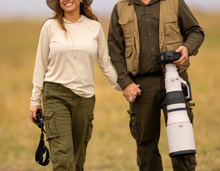 Professional photographer capturing a couple on a safari wedding in Tanzania with wildlife in the background
