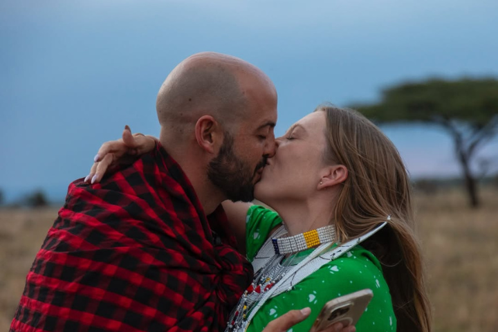 Maasai couple sharing a kiss in traditional Maasai attire during a cultural blessing ceremony in Tanzania