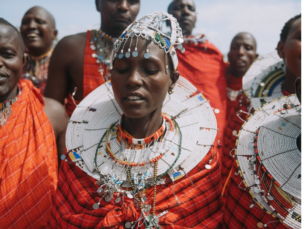 A traditional Maasai elder performs a wedding blessing ritual, sprinkling milk and honey onto an international couple at a safari wedding near Arusha.