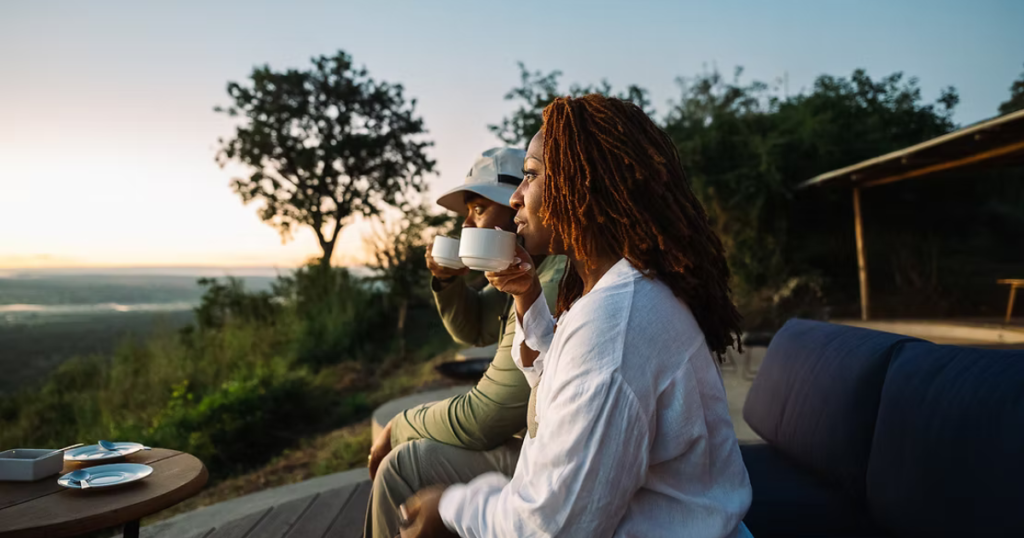 Romantic couple on Tanzania safari honeymoon watching sunrise over Serengeti plains