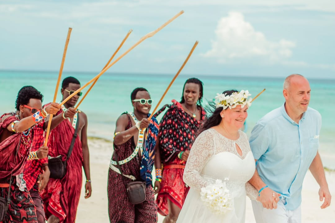 Couple celebrating a symbolic wedding ceremony on a white sand beach in Zanzibar.