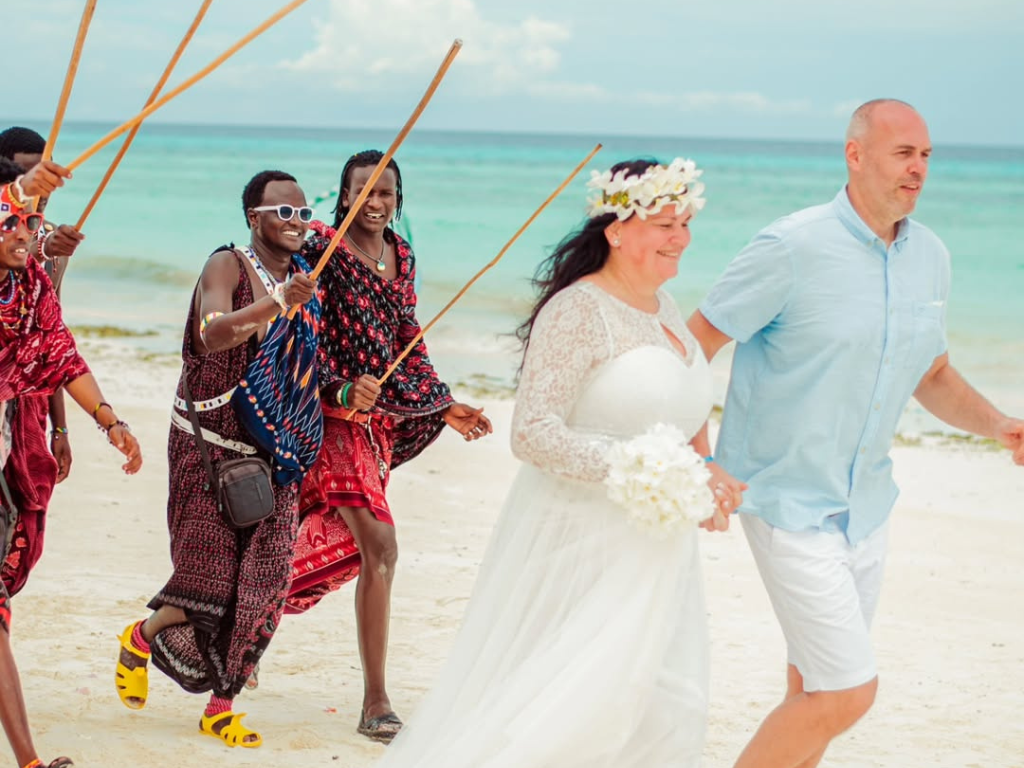 Bride and groom exchanging vows during a symbolic beach wedding in Zanzibar.