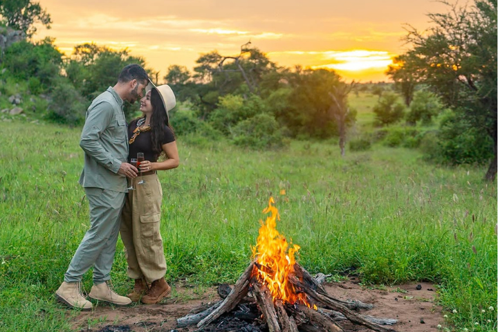 A romantic campfire and bushfire seating setup for couples under a starry night sky at a luxury Tanzanian safari camp.