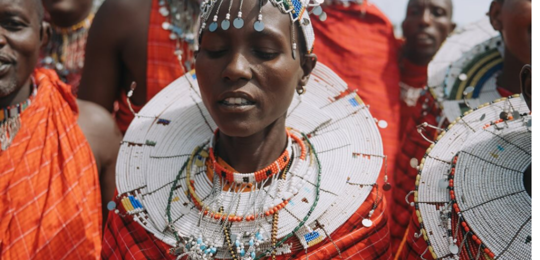 A traditional Maasai elder performs a wedding blessing ritual, sprinkling milk and honey onto an international couple at a safari wedding near Arusha.